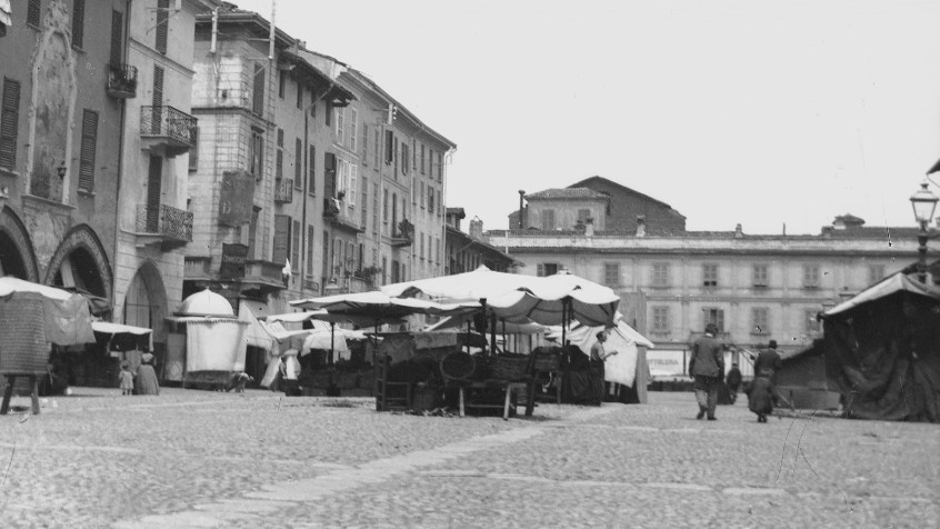 Pavia, piazza Grande ora della Vittoria, veduta da sud con le bancarelle, ante 1913 (CHL NAZ_2)